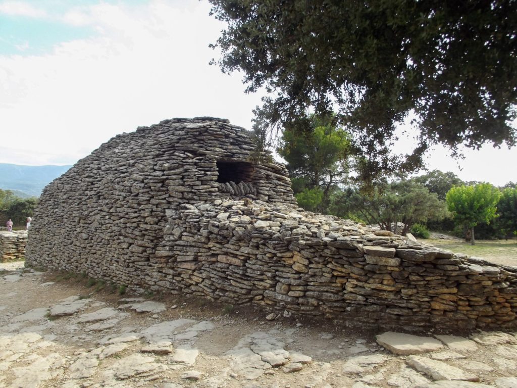 A large hollow dry stone structure with a small opening towards the top.