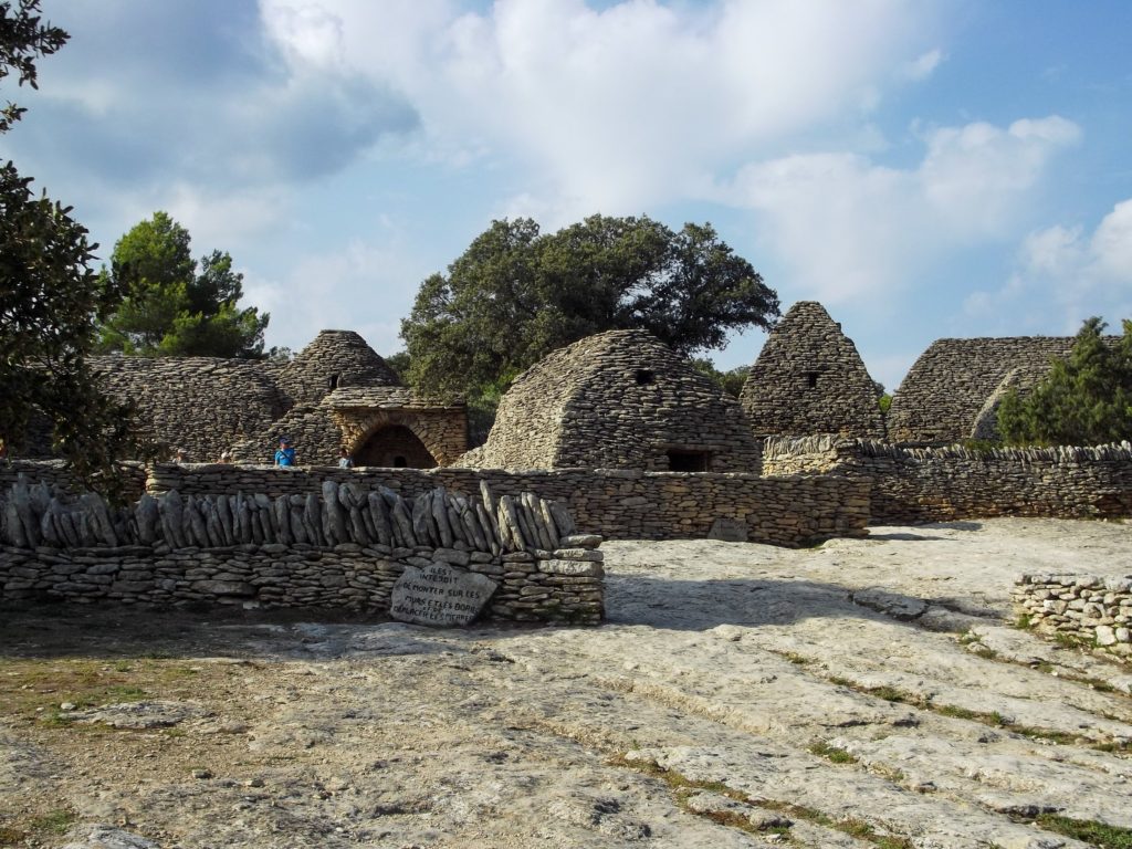 A view of the stone Village of the Bories. Several structures of various shapes and sizes.