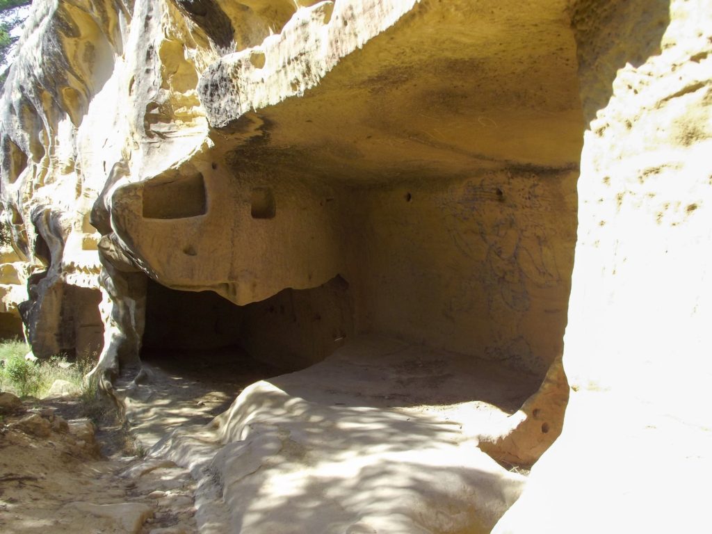 A look inside an old cave carved out of yellow stone.