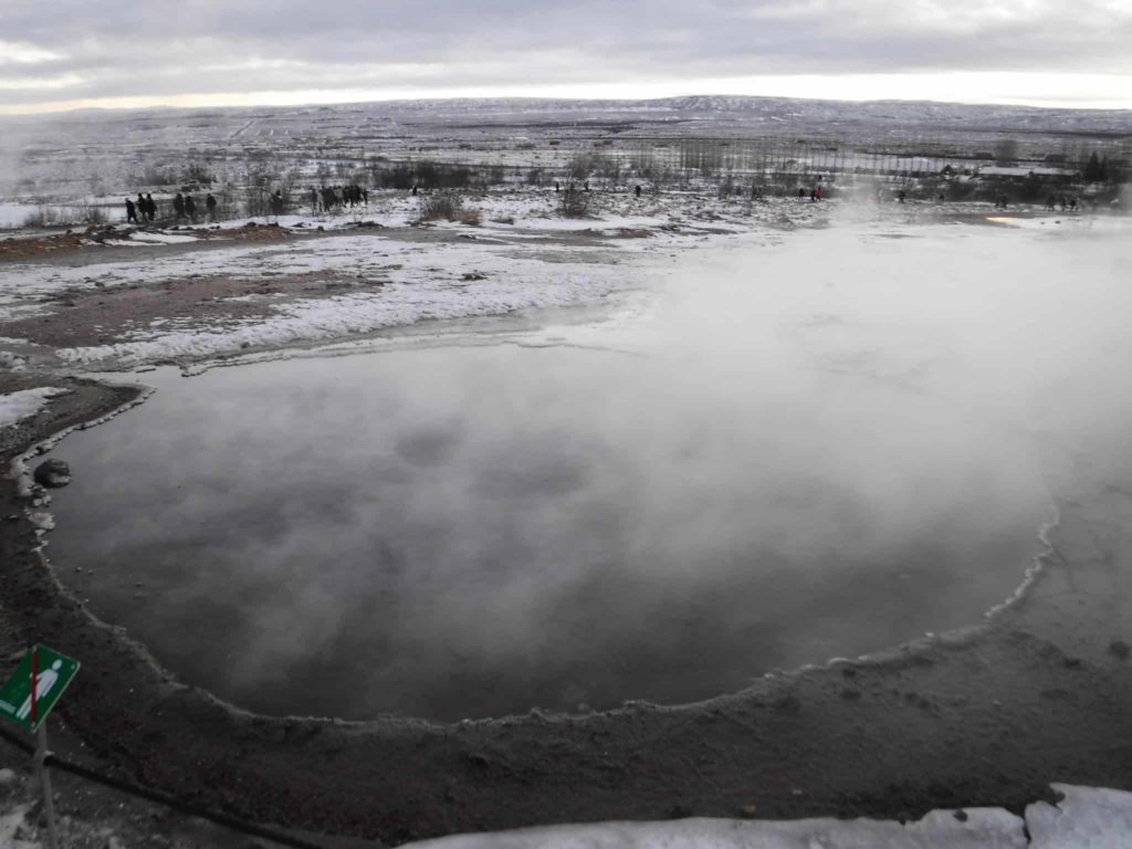 A huge steaming pool is a stark contrast to the snowy landscape.