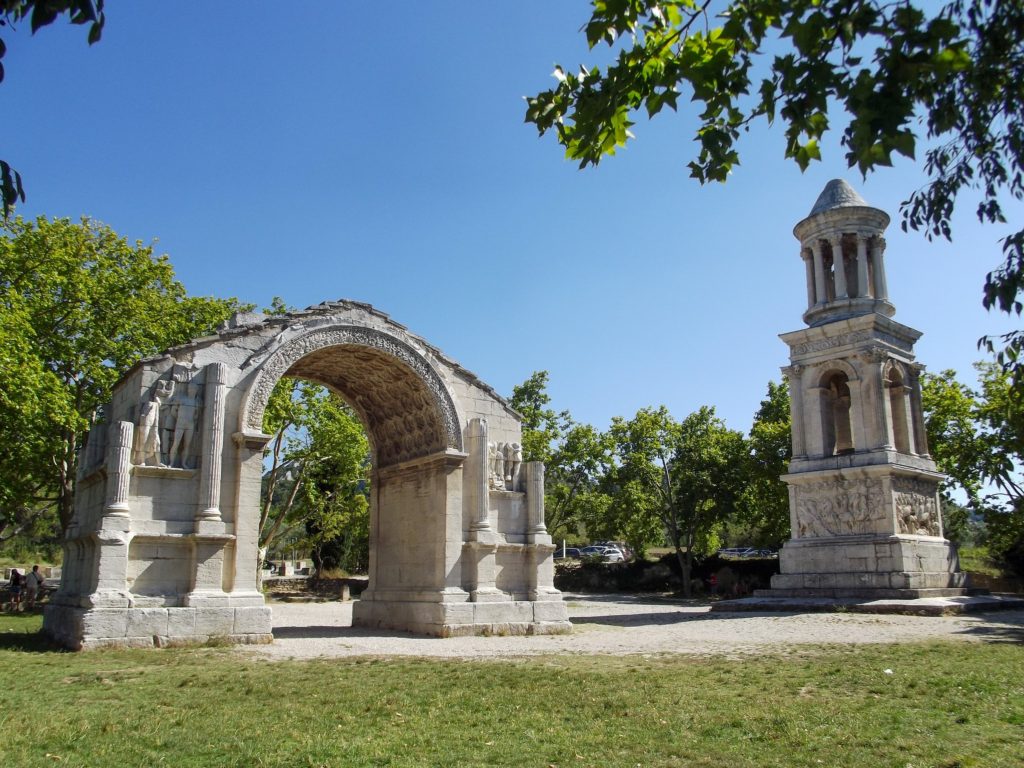 A roman stone arch and bell tower with wonderfully preserved sculptures on them.