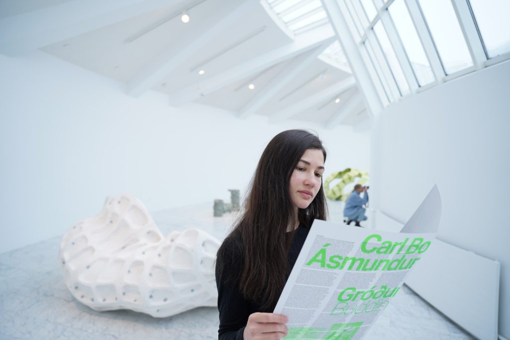 A girl reads an Icelandic museum program.