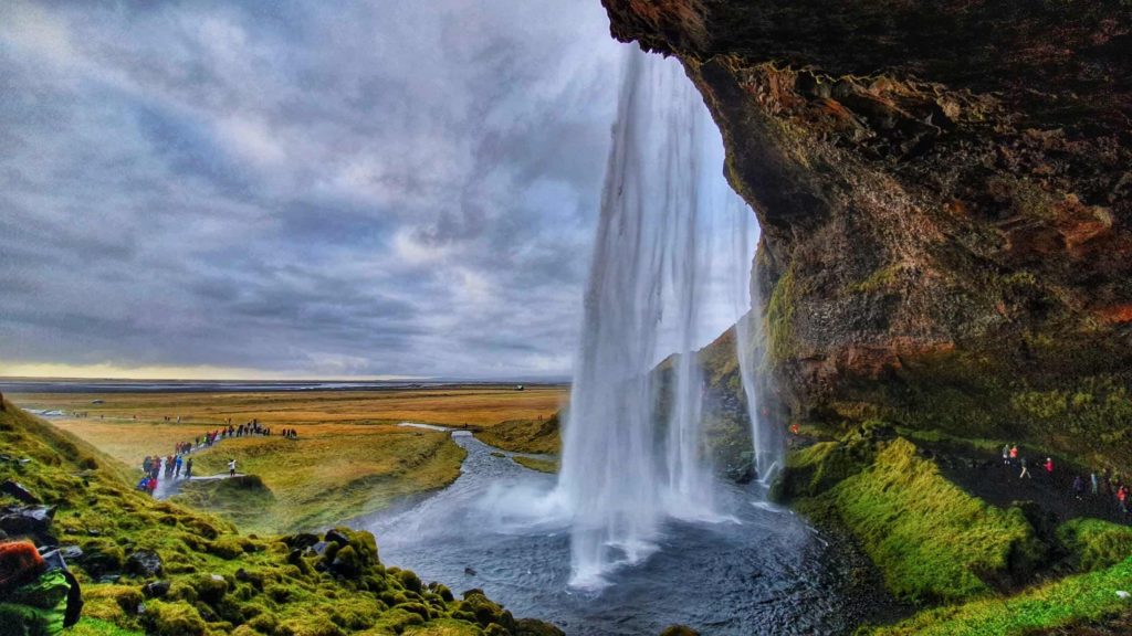 A view from behind the powerful Seljalandsfoss waterfall.