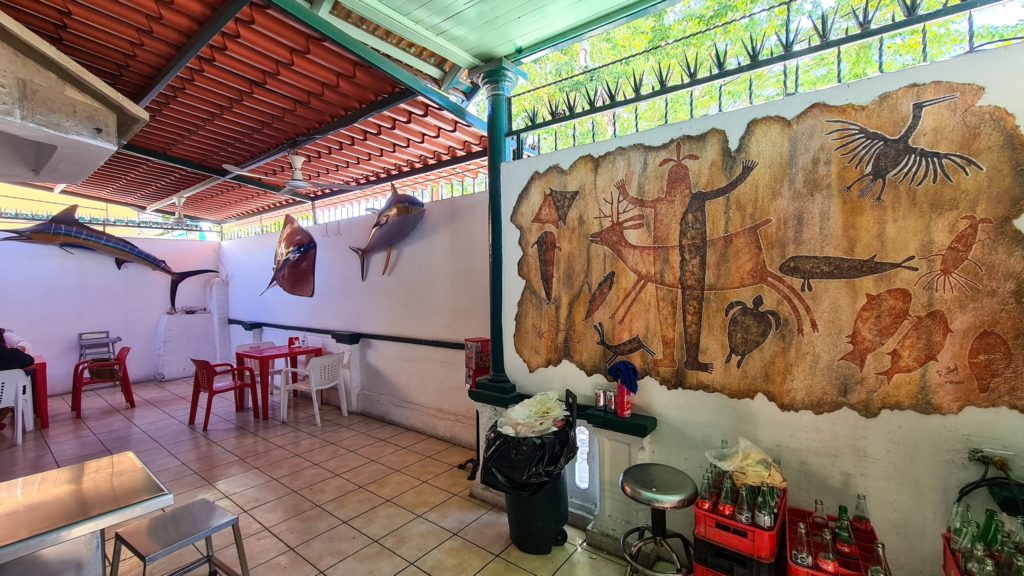 Cave-painting-style art work covers one of the walls at El Estadio.