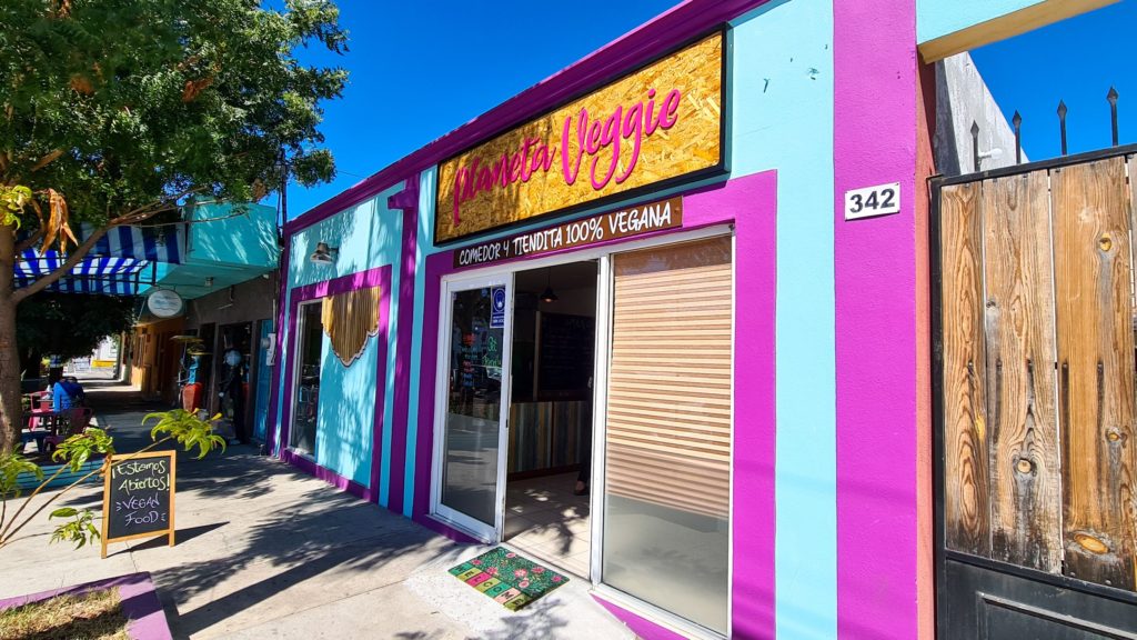The outside of Planeta veggie is bright pink and displays a proud "Vegan Food" sign.