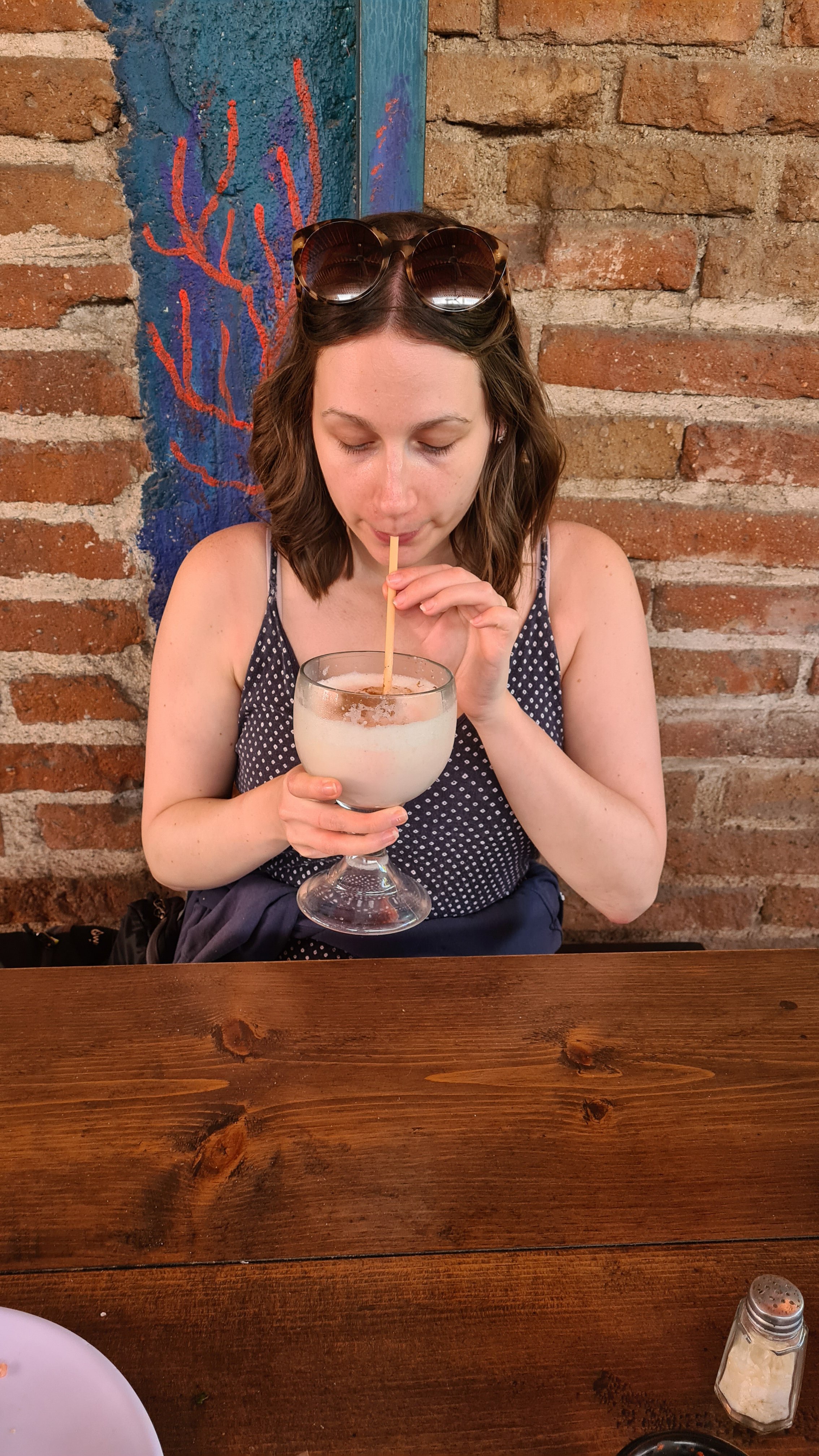 A girl takes a sip of her large cocktail at Mc-Fisher.
