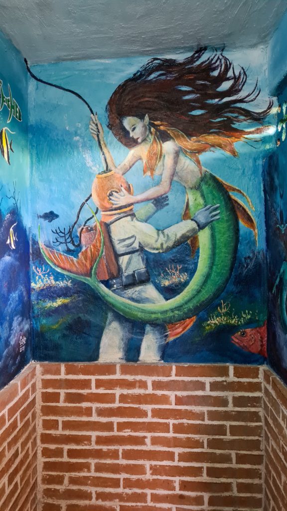 La Paz street art: a mermaid embraces a SCUBA diver in a magical underwater scene.