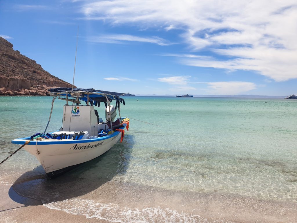 A small tour boat is parked in the clear waters of Balandra Bay, Mexico.