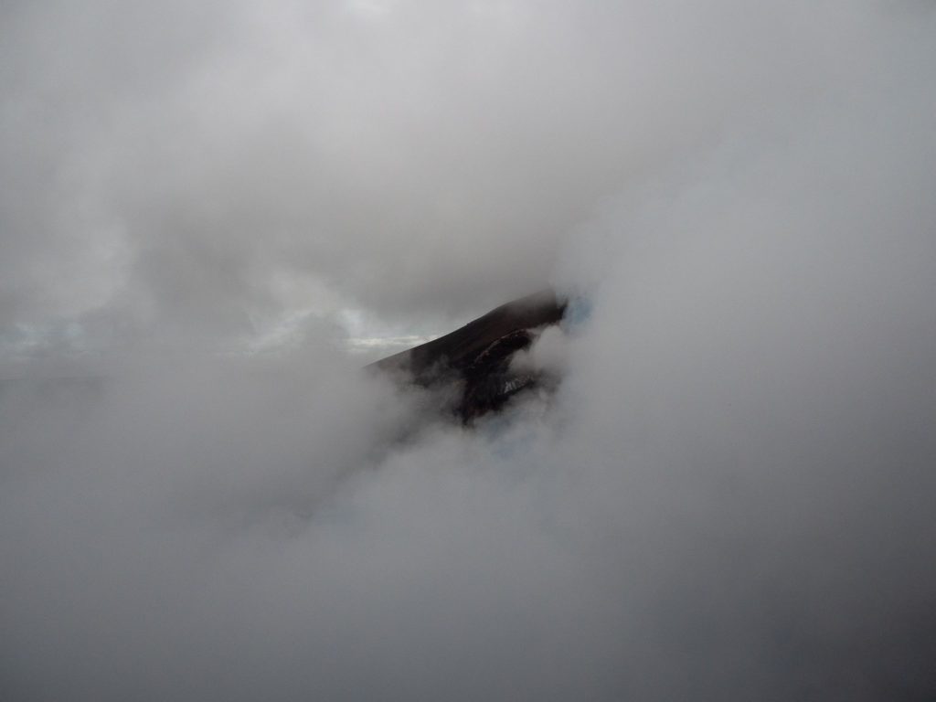 White clouds almost completely cover a dark volcano in Nicaragua.