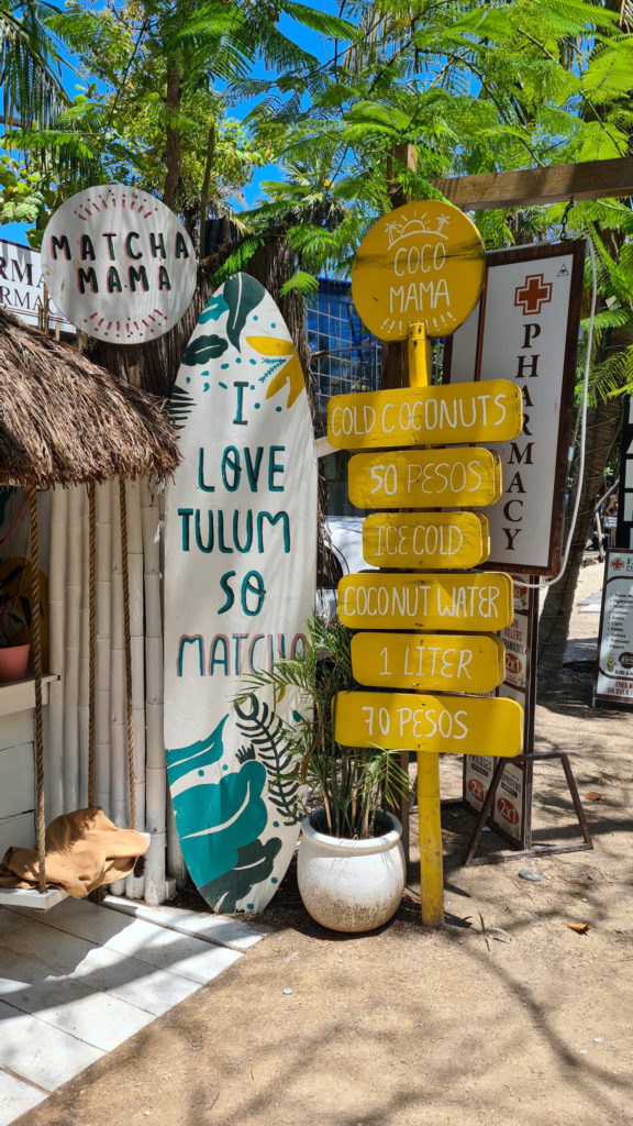 Signs outside Matcha Mama advertise fresh coconuts.