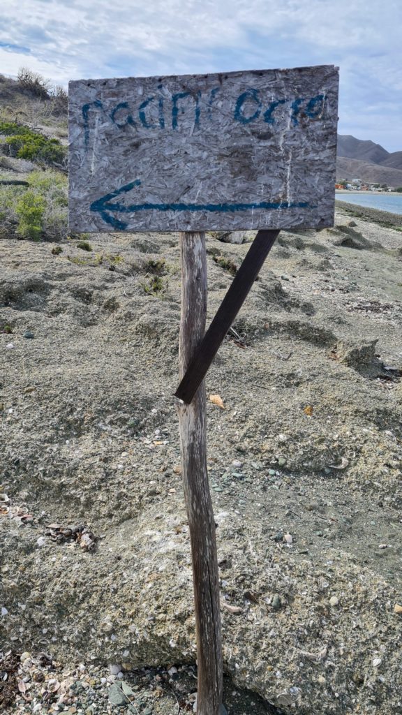 An old sign shows the way to the Pacific Ocean.