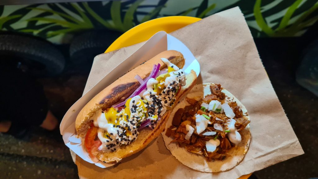A vegan hotdog with all the toppings and a meat-free taco.