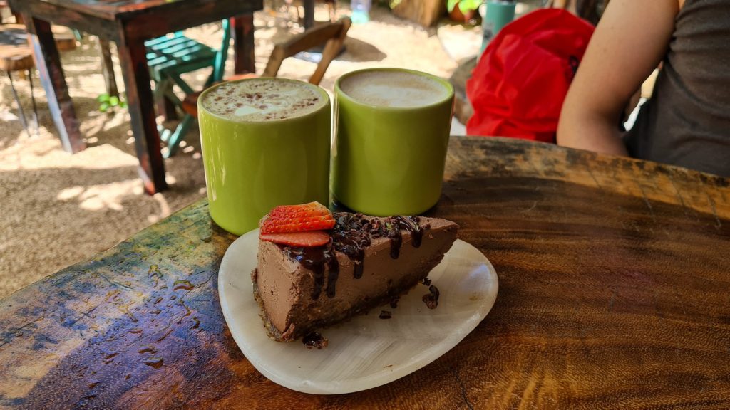 Two mugs of coffee and a chocolate cake.
