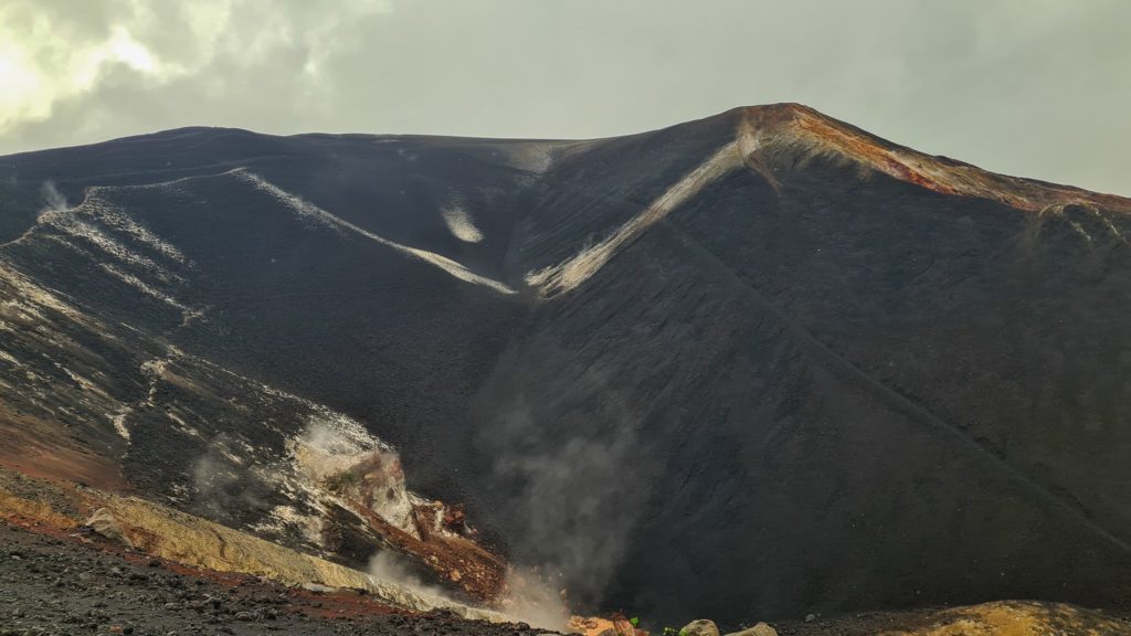 Steam rises from the crater of a volcano.