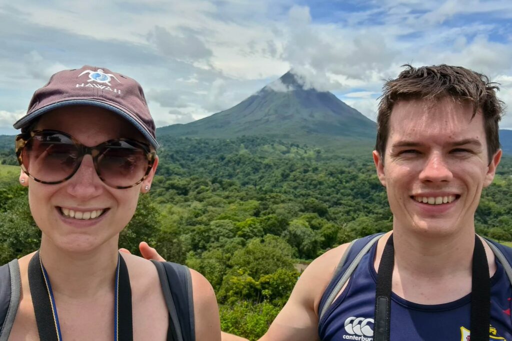 Dan and Lucy standing in front of the impressive Arenal Volcano.