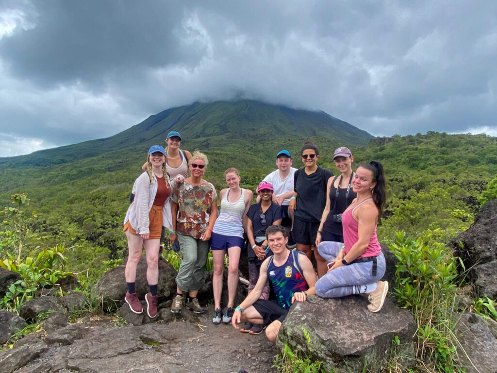 Dan and Lucy pose with a group of friends on a guided hiking tour at the foot of Arenal Volcano.