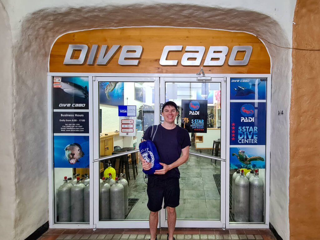 Dan standing at the entrance to Dive Cabo (a dive centre) with a big smile on his face.