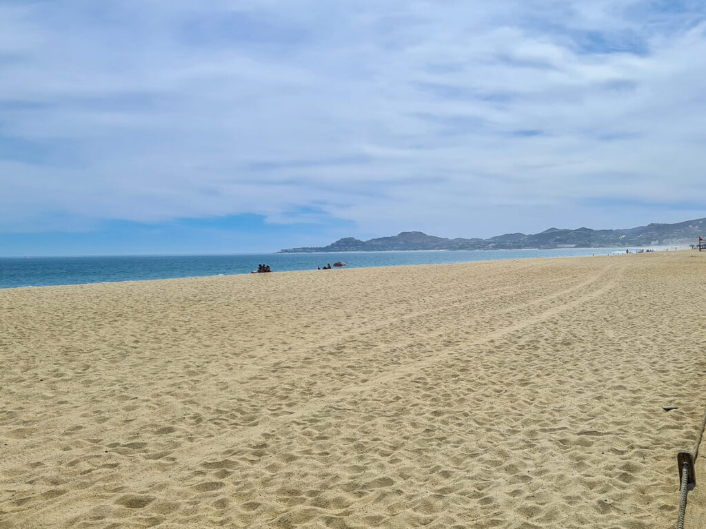 The sands of San José del Cabo Beach stretching far into the distance where a peninsula reaches out to sea.