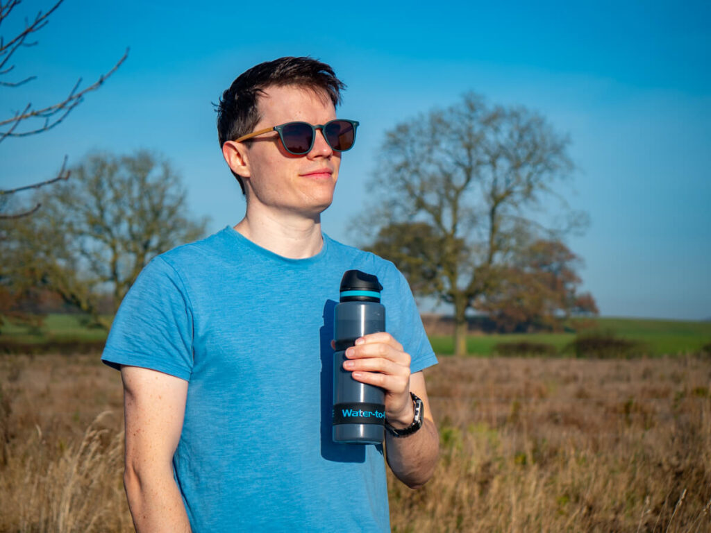 Dan smiling in the sunshine with his active water bottle in his hand.