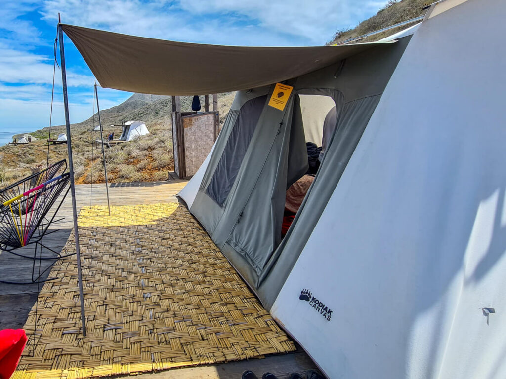 One of the Magdalena Bay Whales Camp glamping tents. There is a small porch area with an awning.