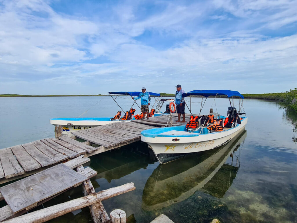 Captains waiting in two boats docked in Sian KaĘĽan Biosphere Reserve, Mexico.