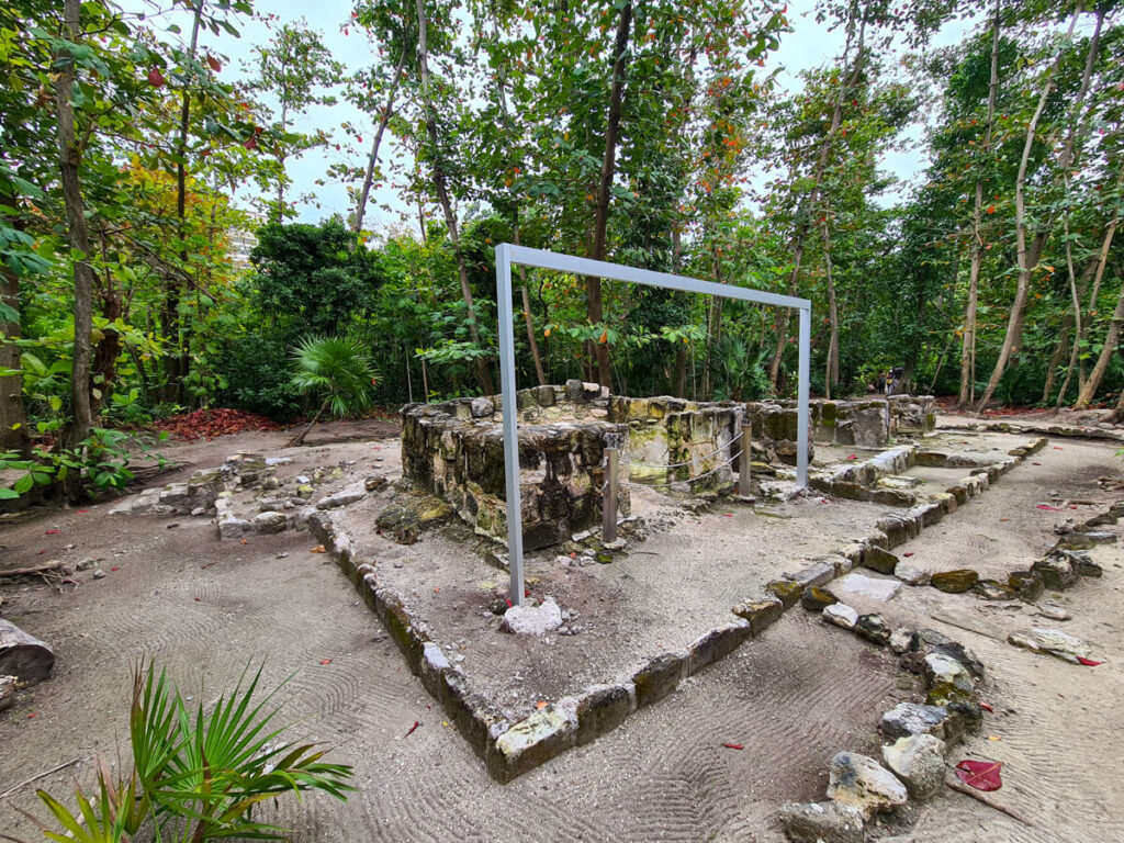 The foundations of an old Mayan building with a metal frame attached to show the original height of the structure.