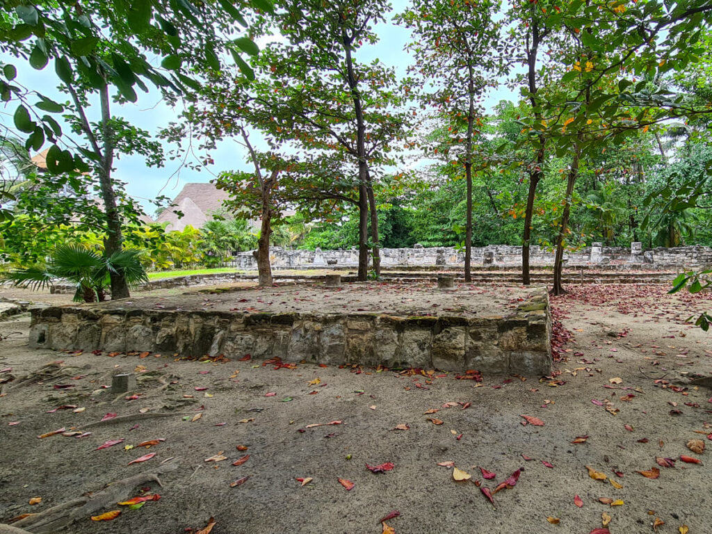 A stone structure rising to about a foot off the ground - the foundations of an old Mayan house.