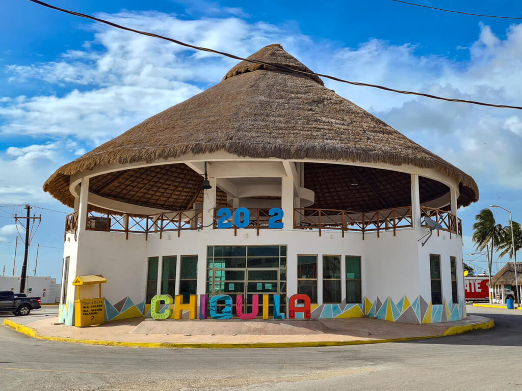 A thatched-rooved building with a multi-coloured sign reading Chiquila.