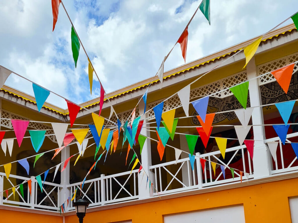 Colourful bunting strung in front of an orange building in San Miguel, Cozumel.