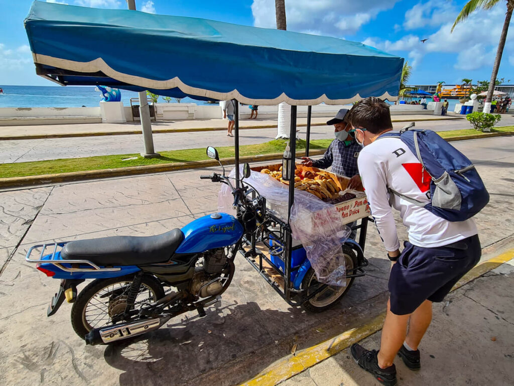 Dan ordering pan dulce from a man with a cart on a motorbike in Cozumel.