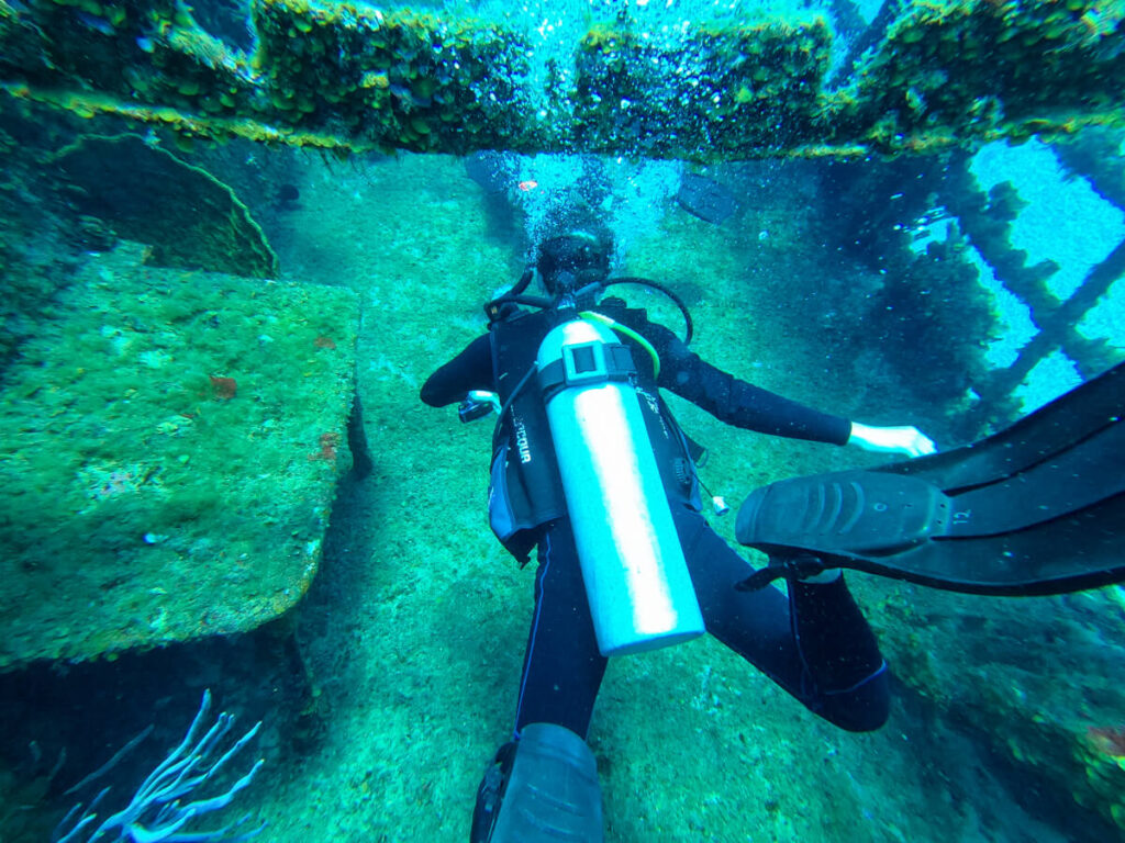Dan SCUBA diving along the top of a shipwreck near Isla Cozumel.