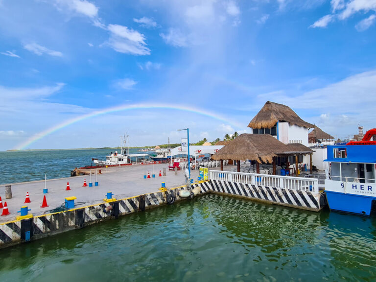 The Holbox Ferry at the dock in Chiquila, backed by a rainbow.