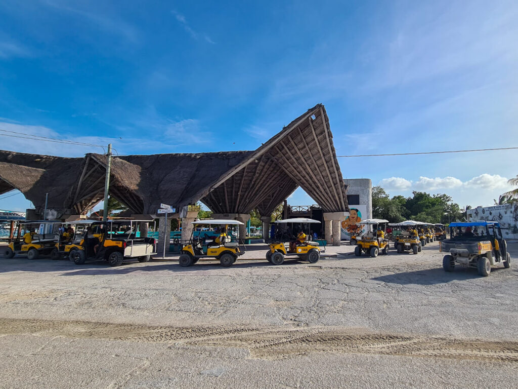Yellow golf carts waiting at the taxi terminal near the Isla Holbox Ferry Dock.