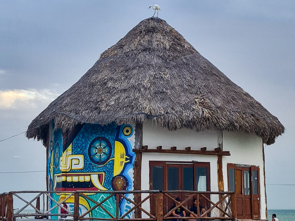 A thatched-rooved building with colourful paintings on the whale shark pier in Isla Holbox.