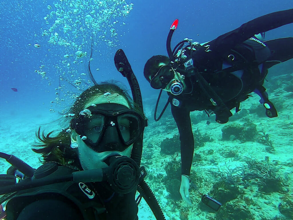 Lucy and Dan taking a selfie underwater while SCUBA diving in Cozumel.