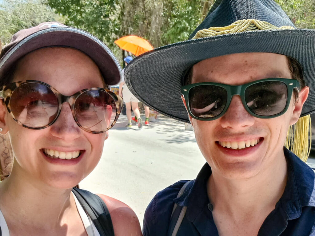 Lucy and Dan in hats and sunglasses smiling at the camera in Tulum, Mexico.