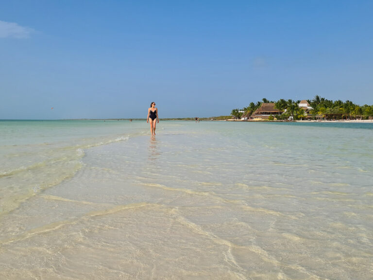 Lucy wading through clear, shallow water on a sandbank at Isla Holbox.