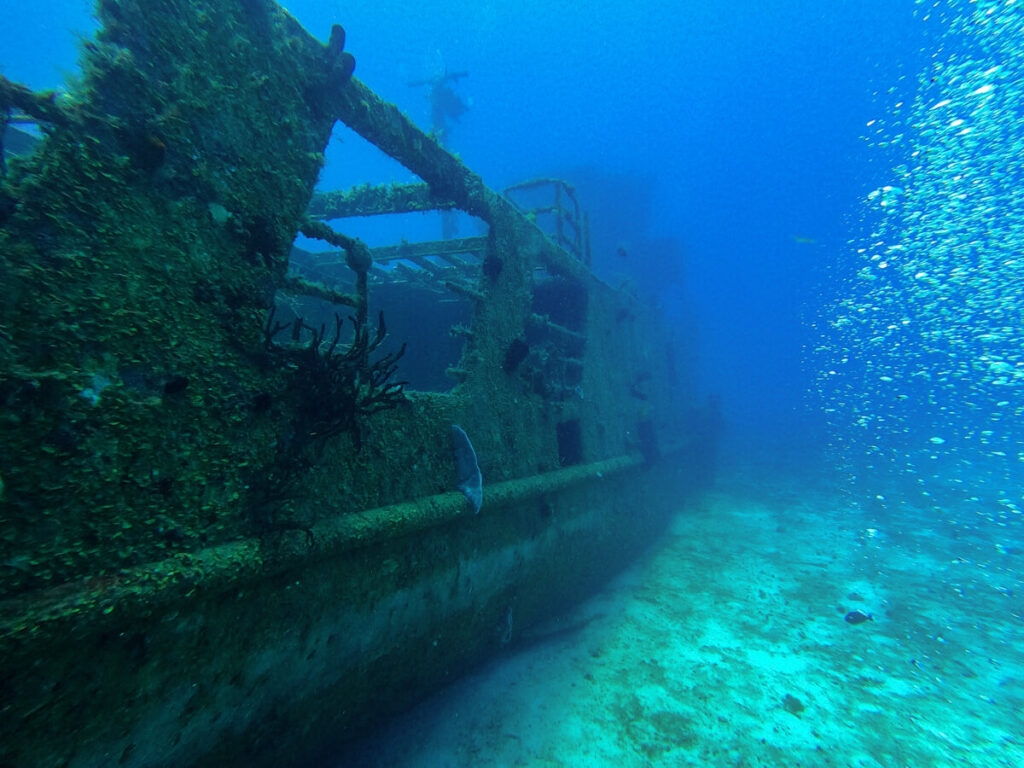 A large shipwreck on the ocean floor at a dive site near Isla Cozumel.