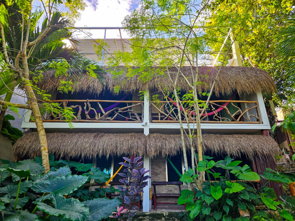 A balcony at the Eco-Hotel Casa Lamat. The roof is in the traditional palapa style and the barrier is made from tree branches.