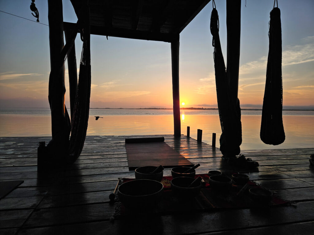 A set-up for sunrise yoga on Bacalar Lagoon. There are some yoga mats and also some singing bowls.