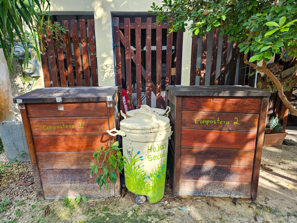 Two large compost bins at the Eco-hotel Casa Lamat. There are also a couple of small containers labelled "Hojas Secas" which translates to "dry leaves". These leaves are used to help the composting process.
