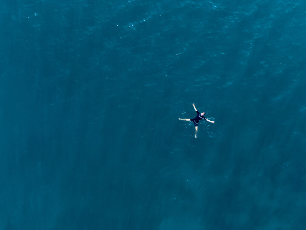 Dan floating on his back in the blue waters of Bacalar lagoon.