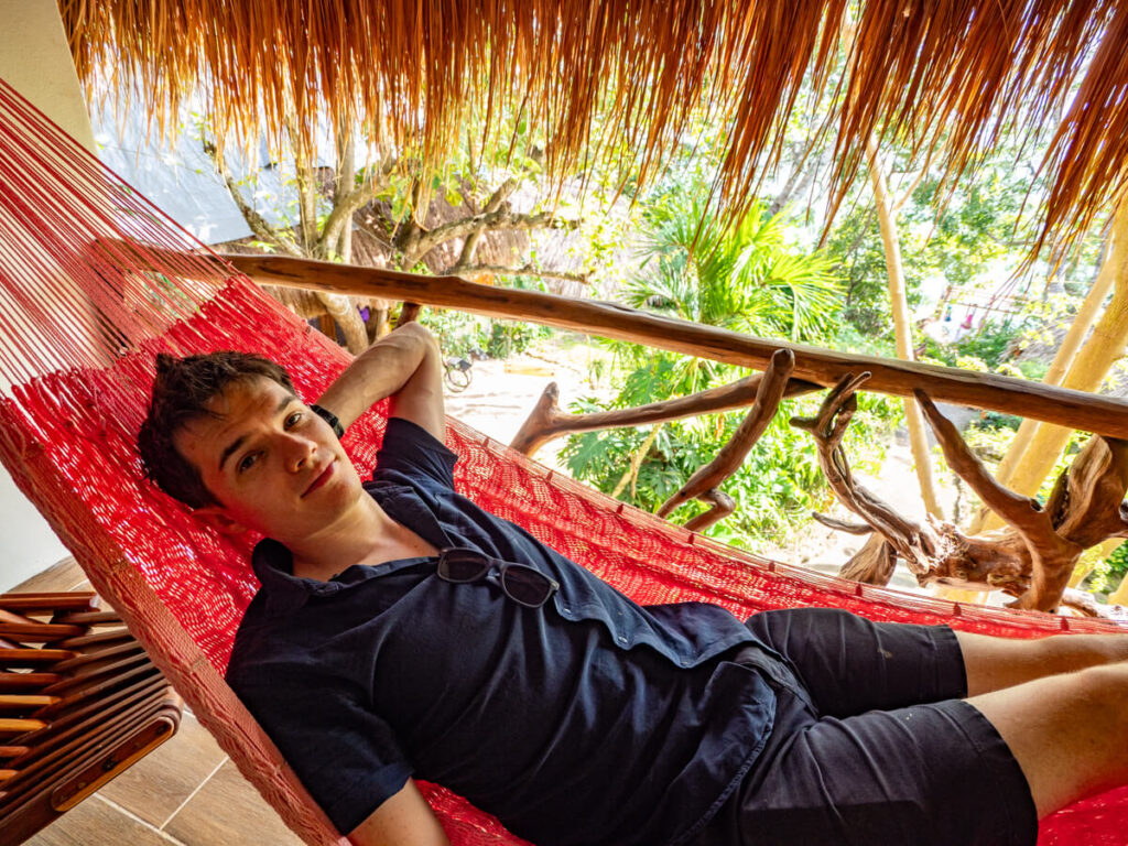 Dan lying on a hammock on a private balcony at the Eco-hotel Casa Lamat.