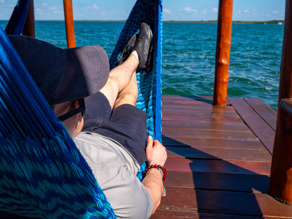 Dan relaxing on a hammock beside the waters of Bacalar Lagoon.