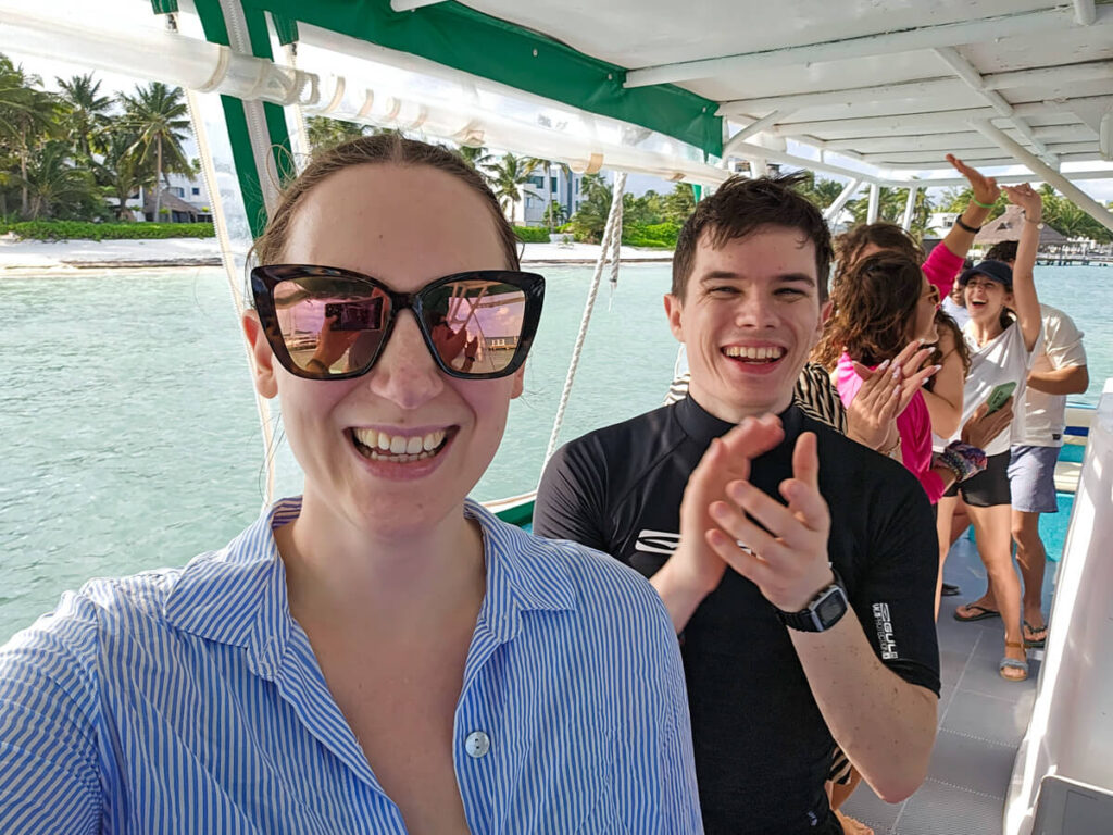 Lucy and Dan dancing and clapping on a boat tour from Cancún with a small group of tourists.