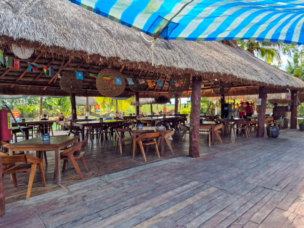 The restaurant and main seating area at Los Rápidos in Bacalar. This large area is covered by a traditional palapa-style roof.