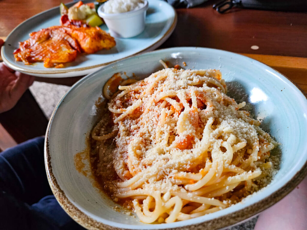 A bowl of spaghetti covered in parmesan cheese, and a plate of fresh fish. These dishes are just a couple of the dinnertime options served at the Eco-hotel Casa Lamat restaurant.