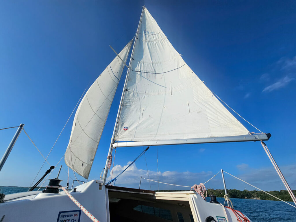 Onboard a small sailboat with open sails on a sunny day.