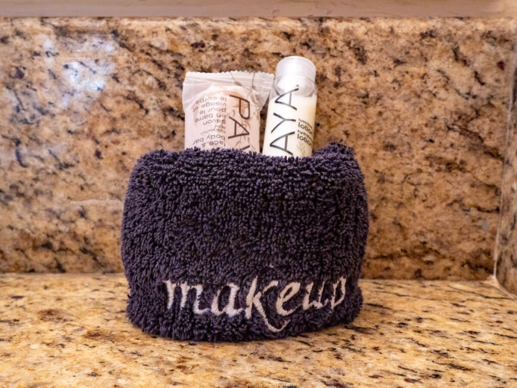 Mini toiletries left for Belizean Shores Resort guests to use. The toiletries have been wrapped in a dark towel with the word "makeup" sewn into it.