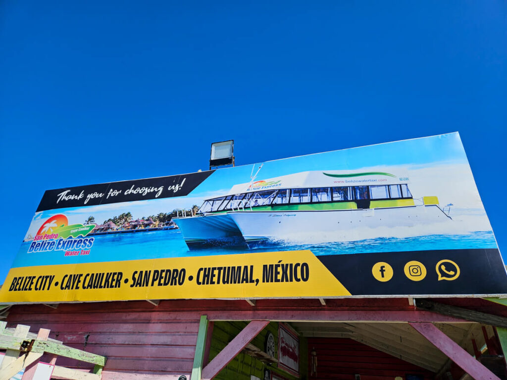 A sign by Belize Express Water Taxi that reads "Thank you for choosing us!" with the destinations along the bottom: "Belize City. Caye Caulker. San Pedro. Chetumal, Mexico.".